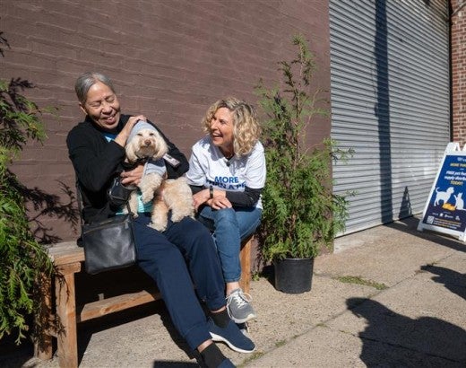 Two people laughing with small dog