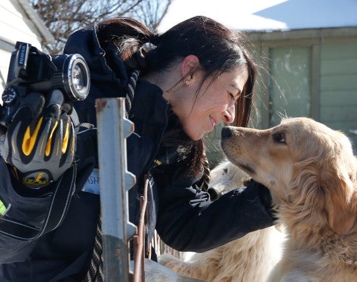 Intern Ashley Mauceri rubs noses with a dog