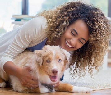 woman playing with her dog in apartment