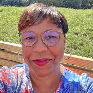 A woman smiles as she takes a selfie