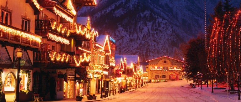 A snow covered street filled with lights at night.