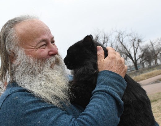 Smiling man holding a cat