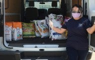 Pets for Life staff member with a van full of supplies