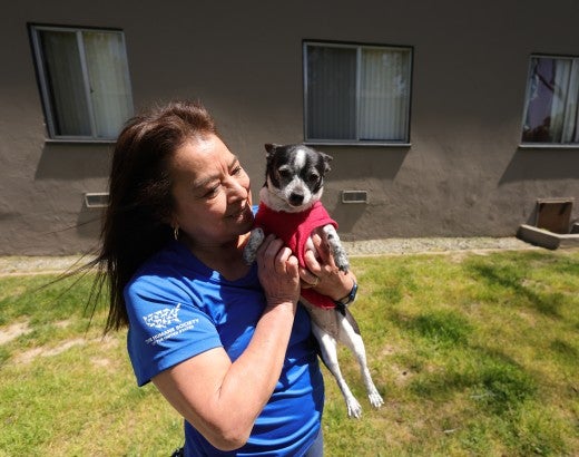 Woman holds and greets a dog