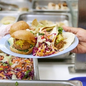 Plant-based food on a plate in a cafeteria.