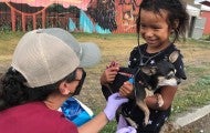 Veterinarian assisting a young girl holding her pet