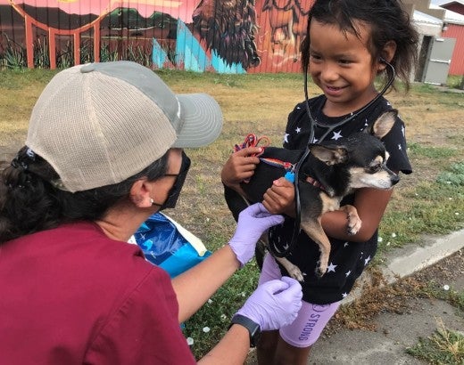 Veterinarian assisting a young girl holding her pet