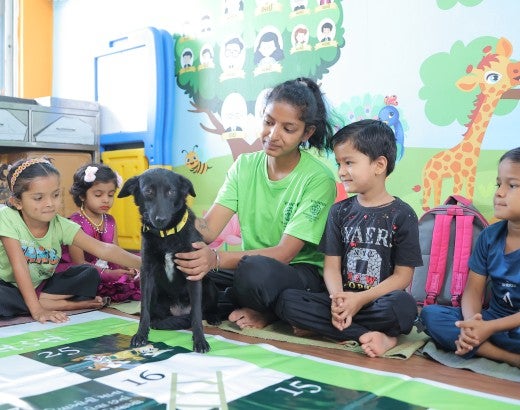 Young children sit with a dog