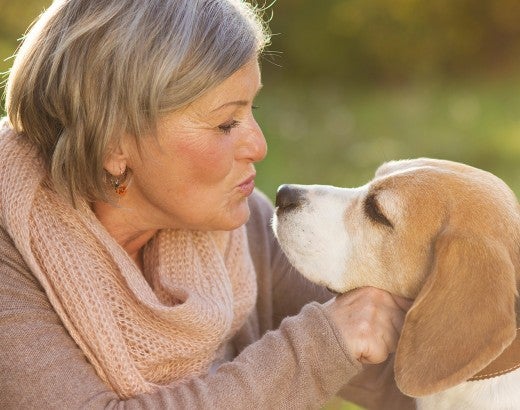 Woman kissing her dog